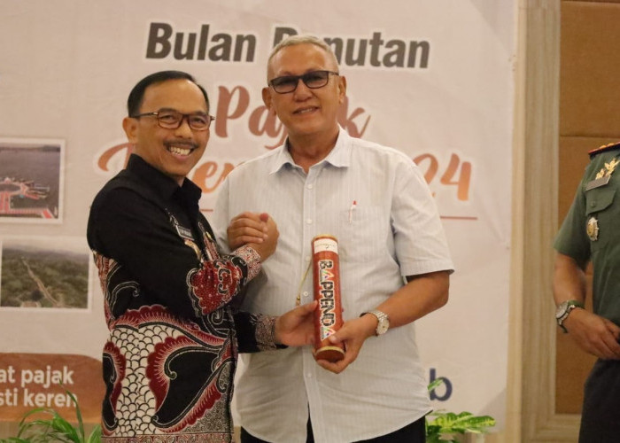 SALAM MESRA. Pj Bupati Kuningan, Dr Drs HR Iip Hidajat MPd bersalaman dengan mantan Bupati Kuningan, H Acep Purnama SH MH saat acara bulan panutan pajak di Hotel Horison, Panawuan, Kuningan.