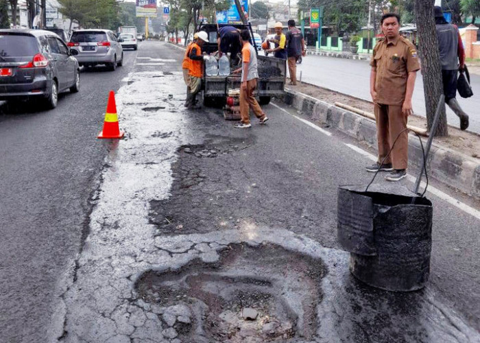 RESPONSIF: Subkoordinator Jalan Jembatan DPUTR Slamet Riyadi Umar bersama tim, mendata dan langsung memperbaiki lubang besar yang membahayakan di Jalan Cipto.