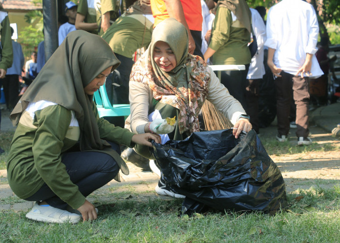 BERSIH: Sekretaris DLH Fina Amalia, membersihkan Taman Kebumen bersama segenap elemen masyarakat dan pelajar. DLH mengajak masyarakat menjaga kebersihan lingkungan.