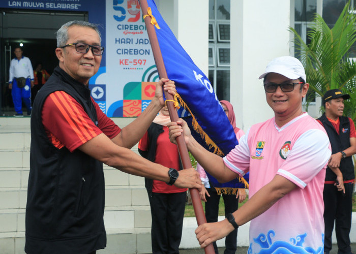  OPTIMIS: Pj Walikota Agus Mulyadi menyerahkan pataka Pemda Kota Cirebon, kepada Ketua Kontingen yang juga Pj Sekda Arif Kurniawan. Kota Cirebon optimis juara Porsenitas.