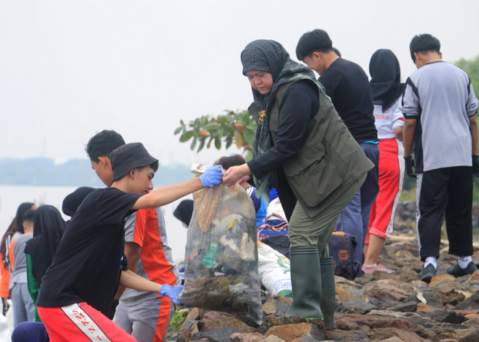 LANGKAH NYATA: Kepala DLH Yuni Darti membersihkan pantai dan sampah liar, bersama ratusan lainnya dalam kegiatan rangkaian HLHS Tahun 2024 Tingkat Kota Cirebon.