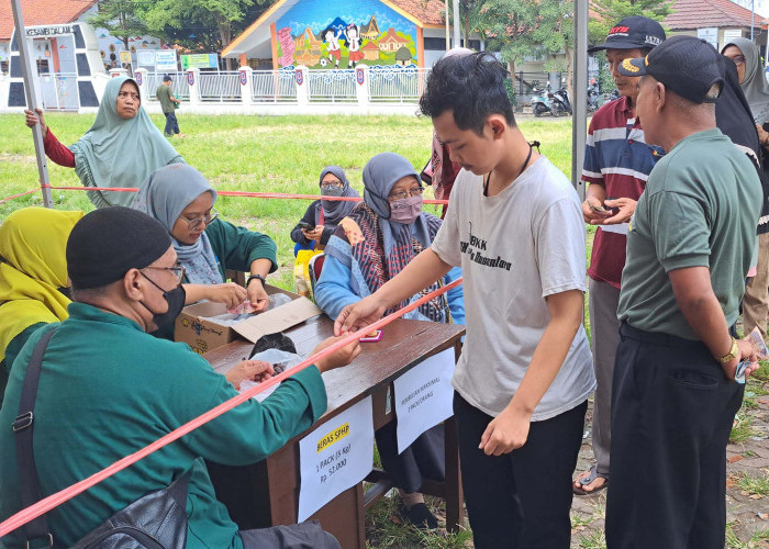 MENGANTRI: Warga yang akan membeli bahan pangan pokok dalam kegiatan GPM, mendapatkan kupon antrian. GPM hadir meringankan beban masyarakat.