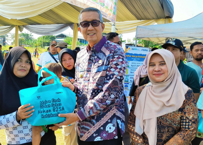 
Foto 2 : CEGAH STUNTING: Pj Walikota Agus Mulyadi didampingi Kepala DKPPP Elmi Masruroh, ssimbolis menyerahkan paket bantuan gratis berisi ikan dan telur kepada warga, sebagai bentuk nyata upaya mencegah stunting.