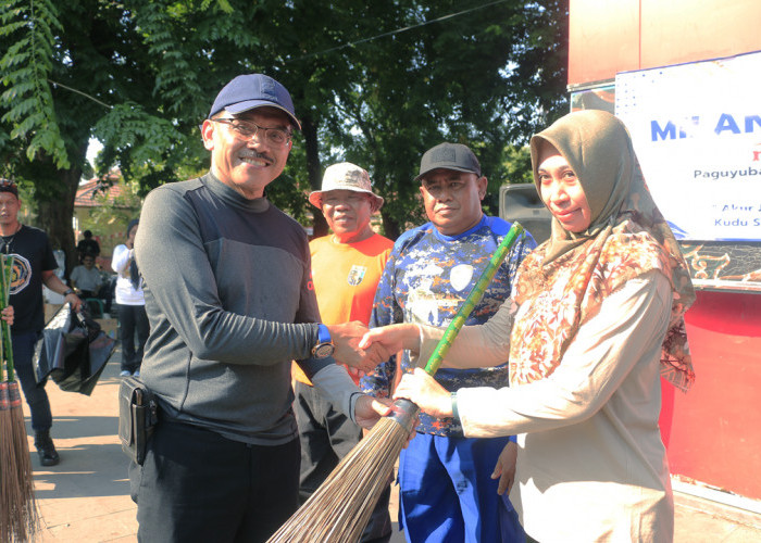 SIMBOLIS: Pj Sekda Iing Daiman, secara simbolis menyerahkan peralatan kebersihan, kepada Sekretaris DLH Fina Amalia, saat kegiatan bersama clean up Taman Kebumen.