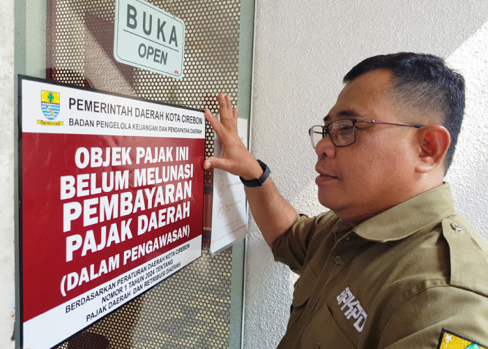 TEGAS: Kepala BPKPD Mastara, memasang stiker penunggak pajak, di depan restoran yang belum membayar kewajibannya. Pajak restoran titipan konsumen untuk pemerintah.