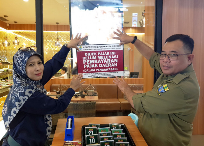 PASANG STIKER: Kepala BPKPD Mastara dan Kabid PPEPD BPKPD Novia Zulianty, memasang stiker penunggak pajak, pada restoran terdata penunggak pajak, baik yang berada di dalam maupun luar mall Kota Cirebon.