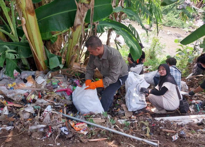 SEMANGAT: Plh Kabid Kebersihan dan Pertamanan DLH Kabupaten Cirebon H Trio Ahdiyanto membersihkan sampah pinggir sungai.