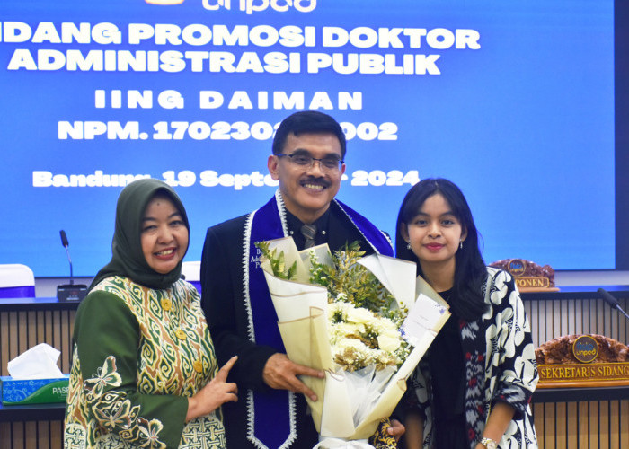 KELUARGA: Kepala DKUKMPP Iing Daiman bersama istri dan putrinya, usai dinyatakan lulus dalam Sidang Promosi Doktor Administrasi Publik Unpad, Kamis (19/9).