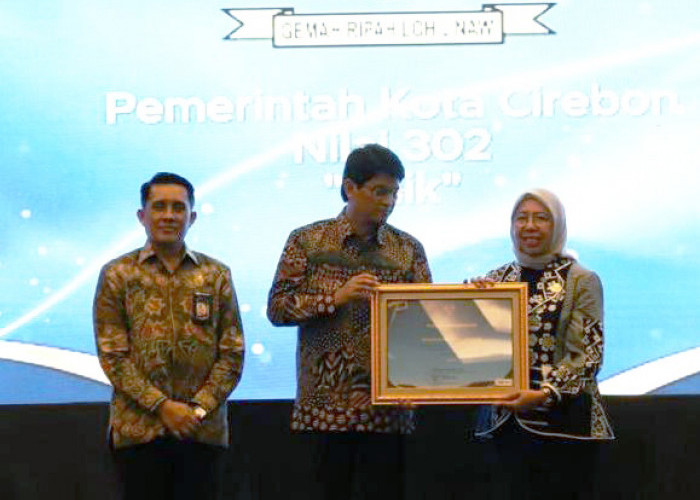 NASIONAL: Kepala BKPSDM Sri Lakshmi Stanyawati, menerima penghargaan nasional dari Plt Kepala BKN Haryomo Dwi Putranto di Jakarta, Kamis (19/12). Penghargaan ini diberikan, atas keberhasilan sistem merit di Pemkot Cirebon.