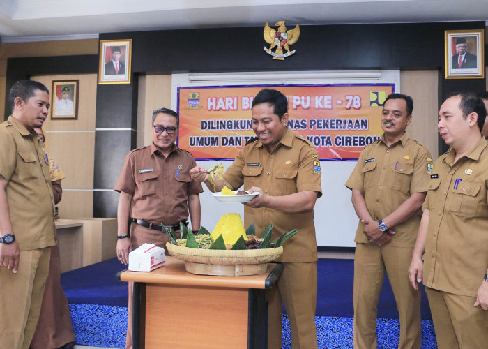 SYUKURAN: Kepala DPUTR Rachman Hidayat memotong tumpeng syukuran Hari Bhakti PU Ke-78. Potongan tumpeng diserahkan kepada Kabid Tata Ruang DPUTR Ario Purdianto.