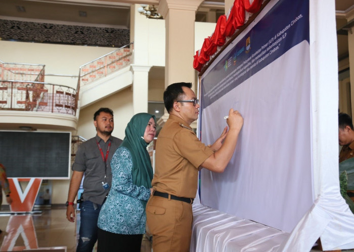 TANDA TANGAN: Pj Bupati Cirebon Wahyu Mijaya tanda tangan saat upacara peringatan Hari Kesehatan Nasional ke-60.