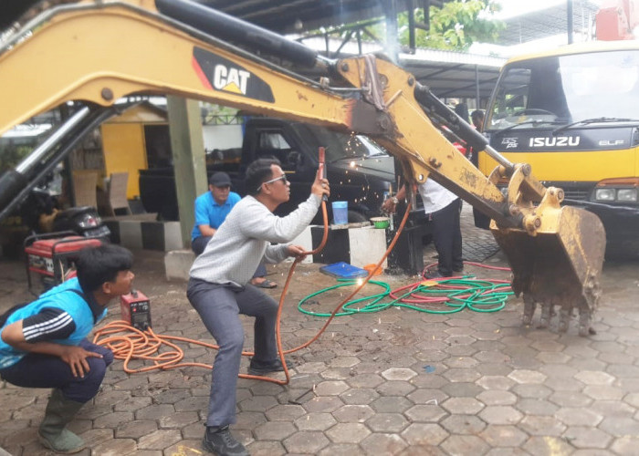 PERBAIKAN: Pegawai UPT Peralatan dan Perbengkelan DPUTR, memperbaiki alat berat yang mengalami kerusakan. Setelah diperbaiki, alat berat dapat digunakan untuk kegiatan.