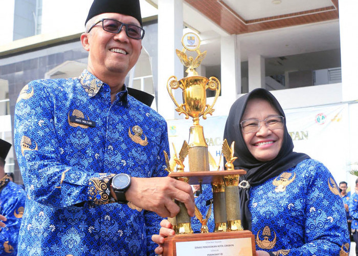 JUARA: Ketua Korpri Kota Cirebon Agus Mulyadi menyerahkan piala juara kepada Kepala Disdik Kadini. Usai upacara, Agus Mulyadi menyerahkan piala, piagam, dan hadiah, kepada para pemenang berbagai lomba yang digelar dalam rangkaian HUT Korpri Ke-52.